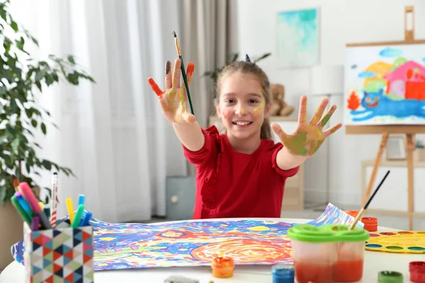 塗られた手と屋内のテーブルで顔と小さな子供 — ストック写真