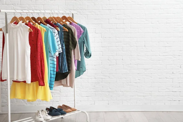 Garderobe Rek Met Stijlvolle Kleding Schoenen Buurt Van Bakstenen Muur — Stockfoto