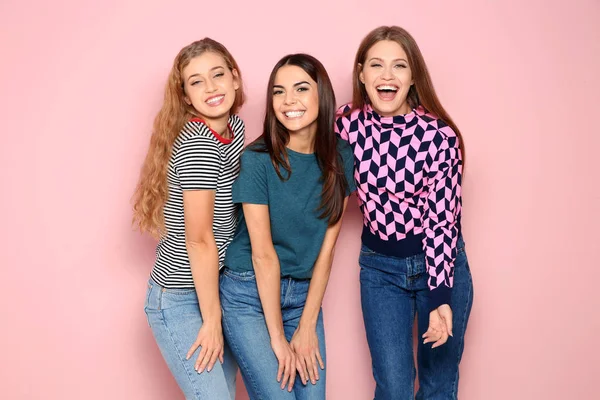 Portrait of young women laughing on color background