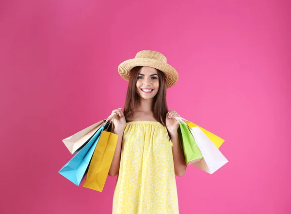 Junge Frau Mit Einkaufstaschen Auf Farbigem Hintergrund — Stockfoto