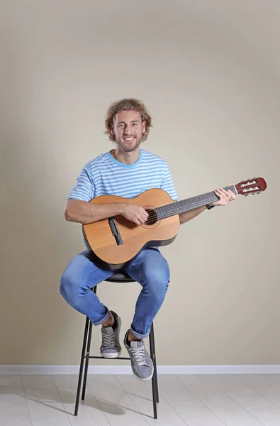 Молодий Чоловік Грає Акустичній Гітарі Біля Сірої Стіни — стокове фото