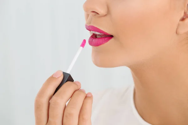 Hermosa Mujer Que Aplica Lápiz Labial Líquido Sobre Fondo Claro — Foto de Stock