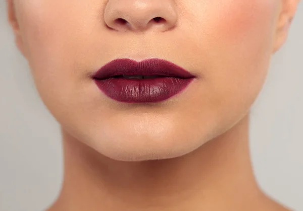 Wanita Muda Mengenakan Lipstik Gelap Pada Latar Belakang Abu Abu — Stok Foto