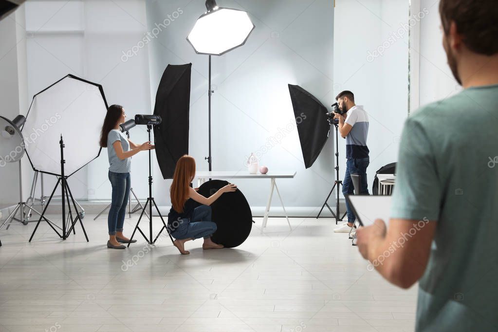 Photo studio with professional equipment and team of workers