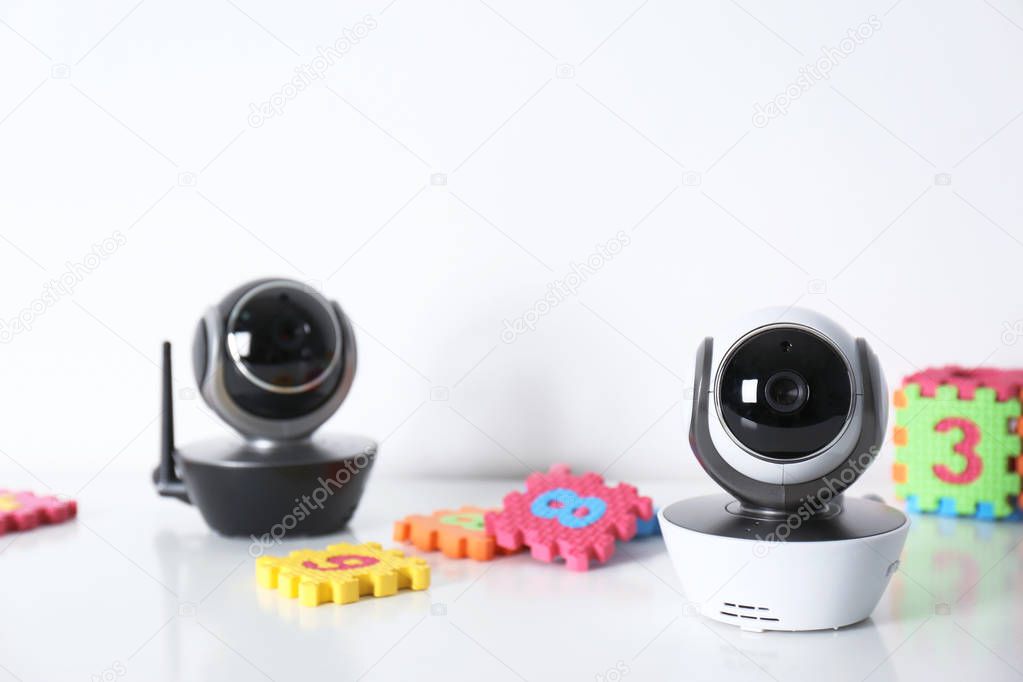 Modern CCTV security cameras and child puzzle on table against white background. Space for text