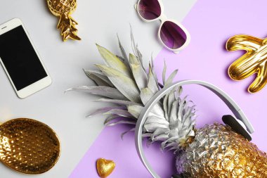 Ananas, smartphone, güneş gözlüğü ve kulaklık renk arka plan üzerinde düz yatıyordu kompozisyonu