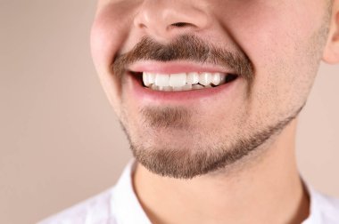 Renk arka planda, closeup gülümseyen sağlıklı dişlere sahip genç adam
