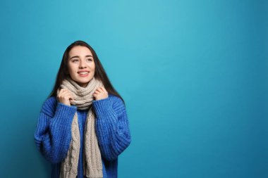 Renk arka plan, metin için yer üzerinde sıcak giysiler giyen genç kadın. Kış sezonu