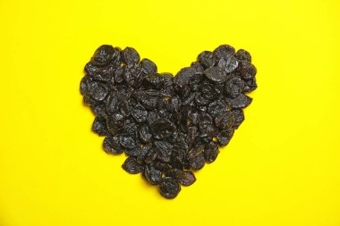 Kalp renk arka plan, üstten görünüm üzerinde lezzetli Kuru Erik yığını şeklinde. Kurutulmuş meyve sağlıklı çerez olarak