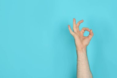 Genç adam gösteren Ok jest renk arka plan üzerinde. Metin için yer