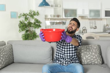 Plastik Havzası su kaçağı tavan ve evde tesisatçı çağıran altında tutan genç adam