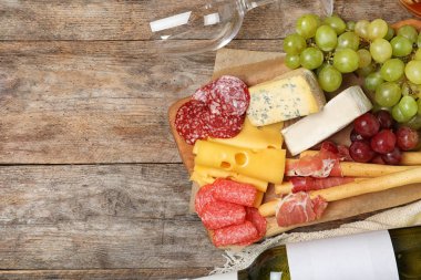 Şarap, aperatifler ve ahşap arka plan üzerinde metin için yer düz yatıyordu kompozisyonu