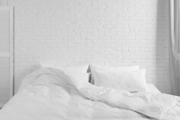 ベッド枕と室内で白いレンガの壁の近くに毛布 スタイリッシュなインテリア — ストック写真