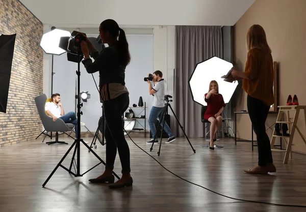 Photo studio with professional equipment and team of workers