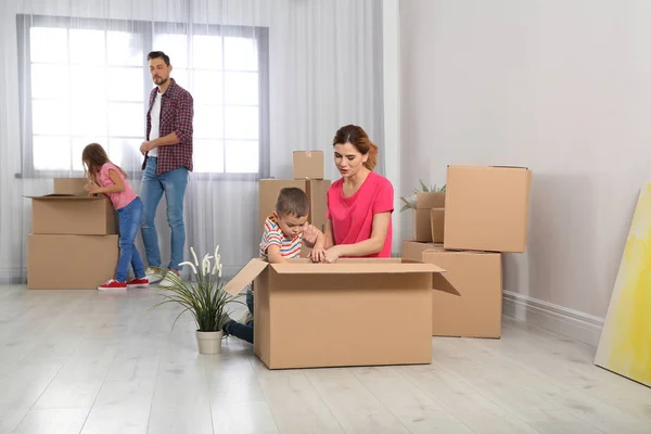 Happy Family Unpacking Belongings Pile Moving Boxes Indoors — Stock Photo, Image