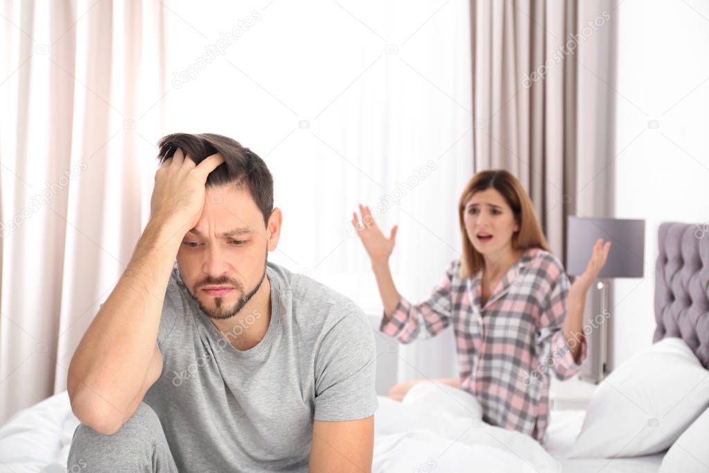 Couple with relationship problems ignoring each other in bedroom