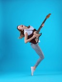 Mladá žena hrát elektrická kytara na barvu pozadí