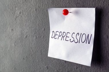 Kağıt Not yazılı kelime depresyon ile gri duvara sabitlenmiş. Metin için yer