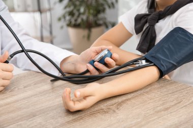 Küçük çocuk ziyaret doktor hastane, portre. Tansiyon ölçme ve nabız kontrol