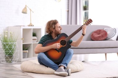Elektro gitar çalmak oturma odasında genç adam. Metin için yer
