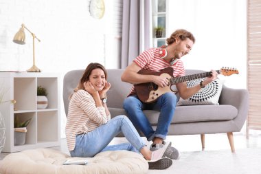 Elektro gitar çalmak oturma odasında genç adam. Metin için yer