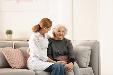 Yaşlı kadın yatak odasında kadın caregiver ile. Metin için yer