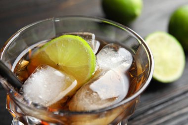 Kola, kokteyl bardak buz ve limon masada, closeup kesti