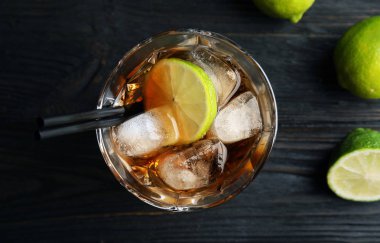 Ahşap arka plan, üstten görünüm üzerinde cola, buz ve kesim limonlu kokteyl bardak