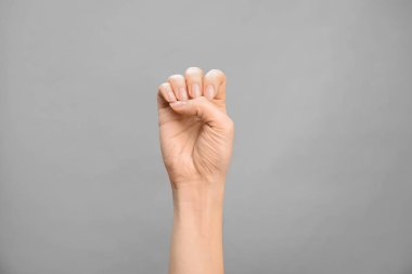 Kadın gösteren E gri arka plan, closeup harfinde. İşaret dili