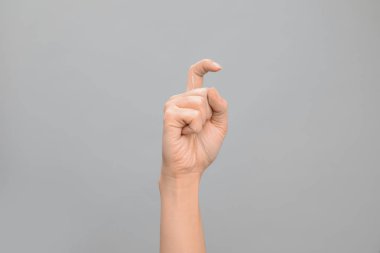 Kadın gösteren X gri arka plan, closeup harfinde. İşaret dili