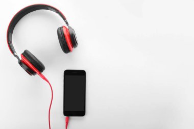 Smartphone ile kulaklıklar beyaz arka plan üzerinde üst görünüm. Metin için yer