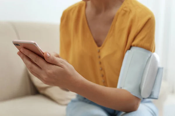 Mulher Verificando Pressão Arterial Com Monitor Moderno Smartphone Dentro Casa — Fotografia de Stock