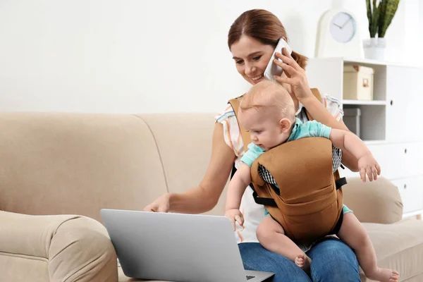 Mujer Con Hijo Portabebés Usando Laptop Hablando Por Teléfono Casa —  Fotos de Stock