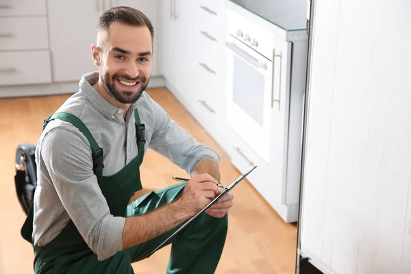 Técnico Masculino Con Portapapeles Examinando Refrigerador Cocina — Foto de Stock