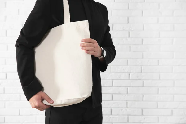 Joven Sosteniendo Bolsa Textil Contra Pared Ladrillo Primer Plano Burla — Foto de Stock