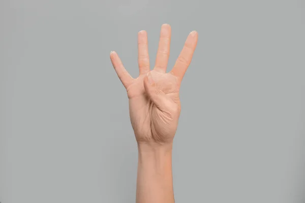 Žena Ukazuje Číslo Čtyři Šedém Pozadí Closeup Znakový Jazyk — Stock fotografie