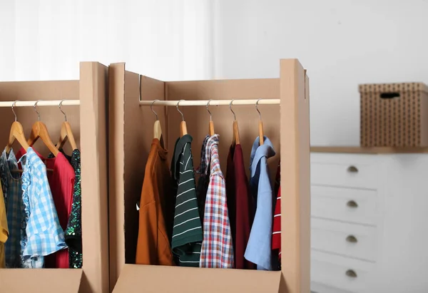 Wardrobe boxes with clothes on hangers indoors