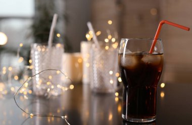Bardak soğuk kola ve peri ışıkları masada. Metin için yer