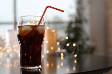 Bardak soğuk kola ve peri ışıkları masada. Metin için yer