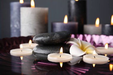 Tabak içinde yanan mumlar ve su ile spa kompozisyon