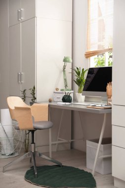 Hafif iş yerinde bilgisayar near evde pencere ile. İç tasarım