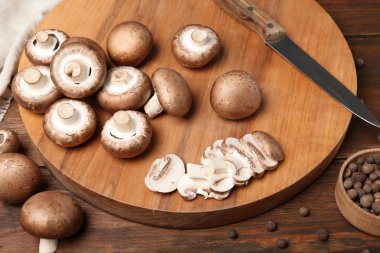 Taze champignon mantar ve ahşap masa üzerinde bıçak ile kesme tahtası
