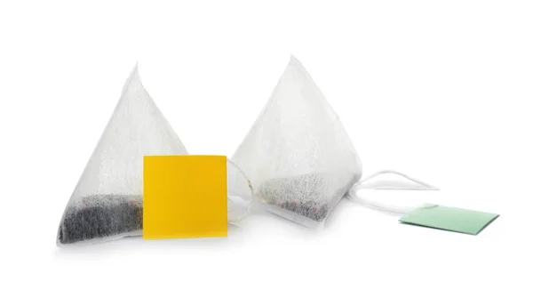 Unused pyramid tea bags with tags on white background. Space for text