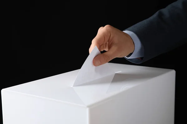 Mann Legt Seine Stimme Die Wahlurne Auf Schwarzem Hintergrund Nahaufnahme — Stockfoto
