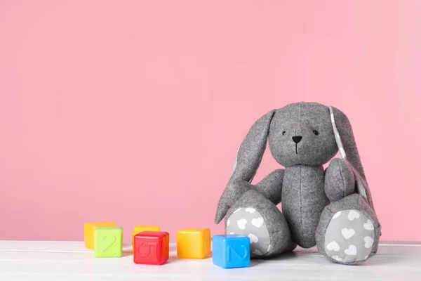 Очаровательные Игрушечные Кролики Пластиковые Кубики Столе Цветном Фоне Место Текста — стоковое фото