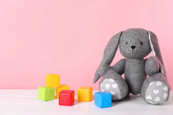 Adorable Conejito Juguete Cubos Plástico Mesa Contra Fondo Color Espacio —  Fotos de Stock