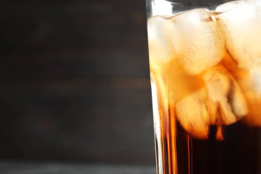 Koyu arka plan, closeup buz küpleri ile lezzetli ferahlatıcı kola bir bardak. Metin için yer