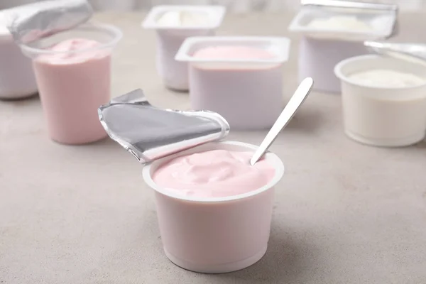 Copa Plástico Con Yogur Fresco Cuchara Mesa Gris —  Fotos de Stock