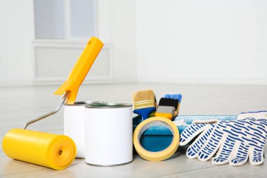 Boya ve dekoratör araçları kapalı ahşap zemin üzerinde bidon