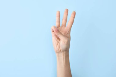 Kadın gösteren W harfi renk arka plan, closeup üzerinde. İşaret dili